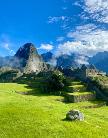 Iconic ancient ruins with a mountainous backdrop.