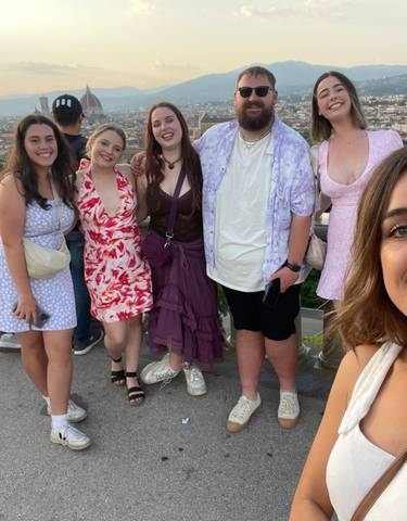 Group of young adults posing with Florence's skyline in the background.