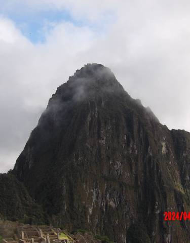 Mountain peak surrounded by mist and clouds.