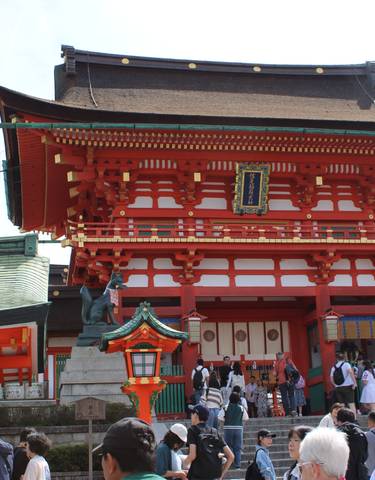 A red traditional Japanese building with visitors.