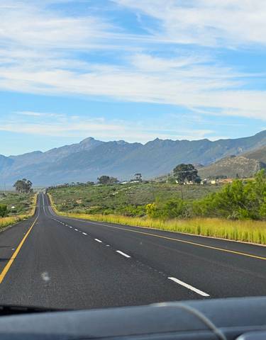 A long stretch of road with mountains in the distance.