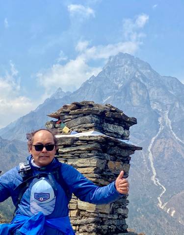 Person posing with a backdrop of mountains.
