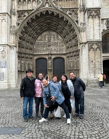 Group of people posing in front of a historic cathedral.