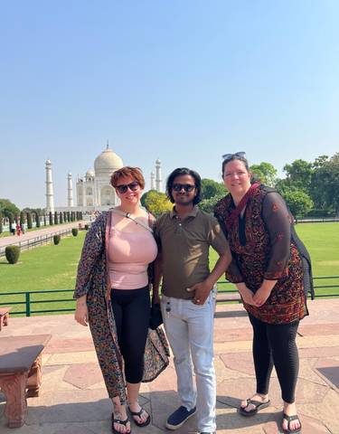 Group posing with the Taj Mahal in the background.