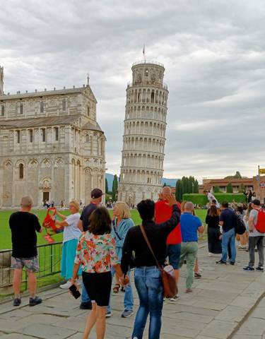 Crowd around the Leaning Tower of Pisa on a sunny day.