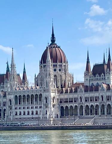 Elegant building with spires by a river.