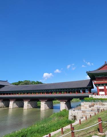 Traditional Korean palace building with a bridge over water.