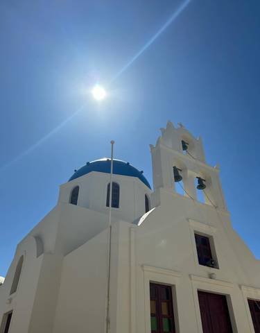 Iconic blue domed church under bright sunlight.