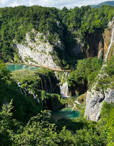 Scenic aerial view of cascading waterfalls and greenery.