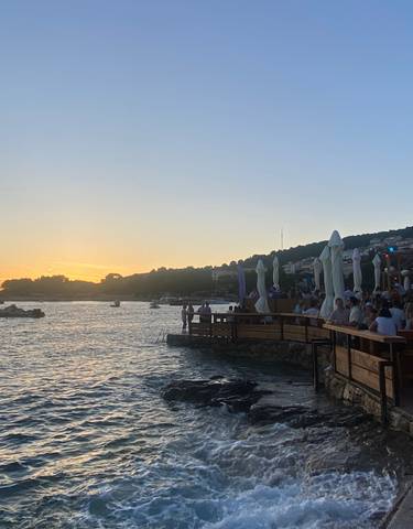 A scenic view of the sea with a setting sun in the background.