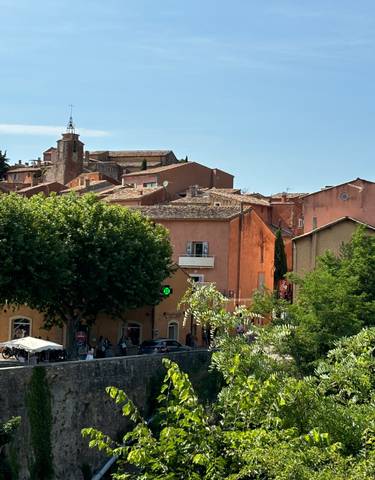 A colorful village with trees and church tower.