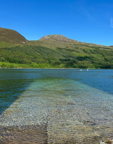 Beautiful lake with a mountainous background and clear water.