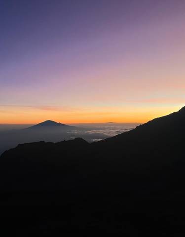 Silhouette of mountains during sunset with vibrant sky.