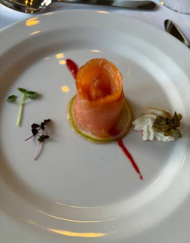 Plated dish with smoked salmon, greens, and capers.