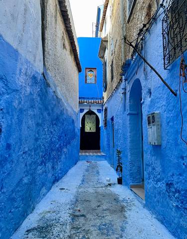 Narrow alleyway with vibrant blue painted walls.