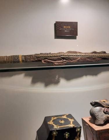 A historical sword displayed in a museum environment with subdued lightning.