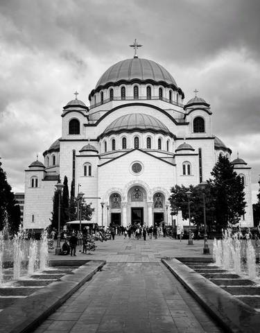 Large white cathedral with multiple domes and fountains in the foreground.