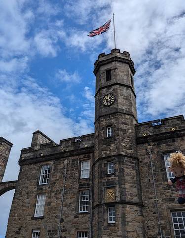 Historic clock tower and castle under a blue sky.