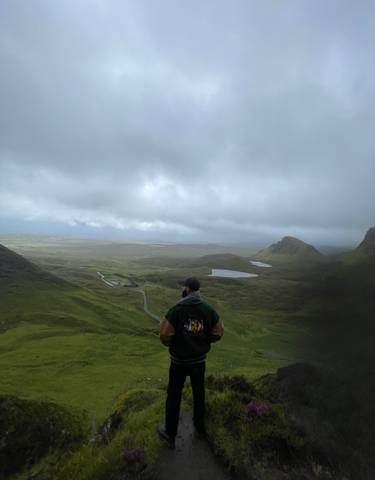 Person viewing scenic landscape of valleys and lakes.