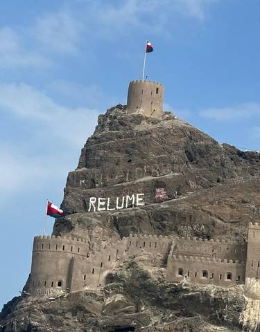 Mountain fortress with flags and 'RELUME' sign.