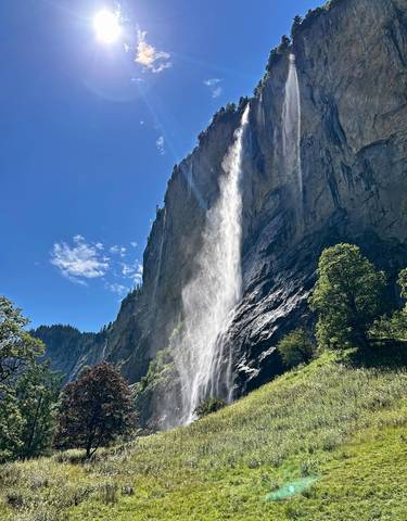 Dramatic waterfall cascading down a rocky cliff with lush greenery.