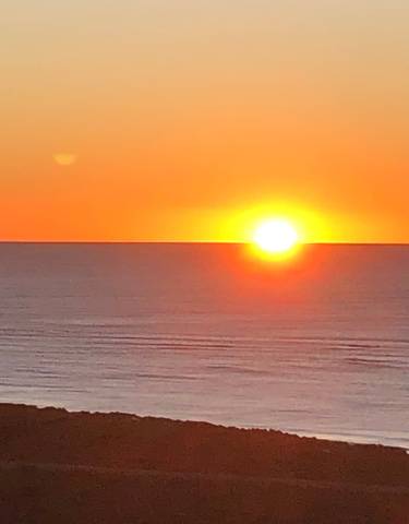 Sunset over the ocean with a clear sky.