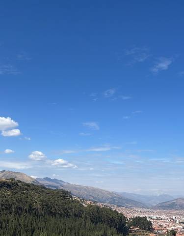 Wide view of a city with mountains and blue sky