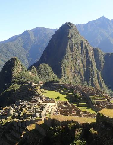 Panoramic view of Machu Picchu with surrounding mountains.