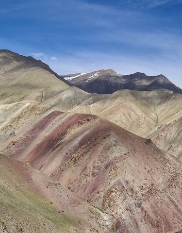 Deserted rugged mountains under blue sky.
