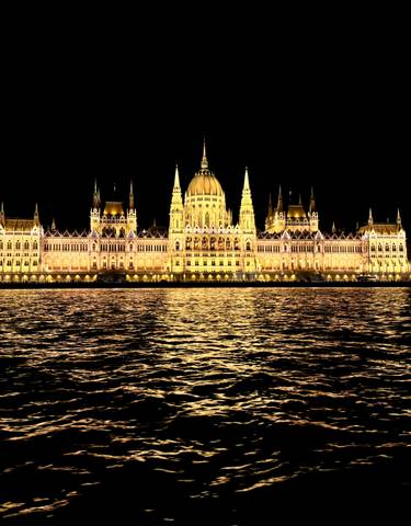 The Hungarian Parliament illuminated at night reflecting in the river.