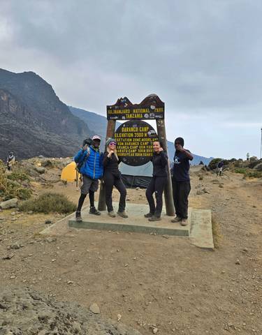 Hikers posing in front of a national park sign.