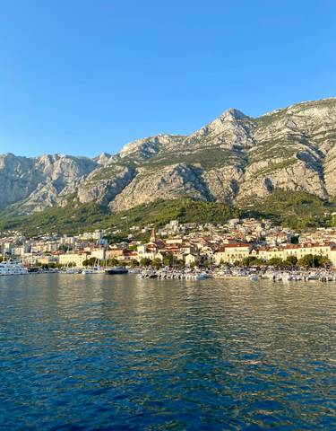 Scenic view of a coastal town with mountains in the background.