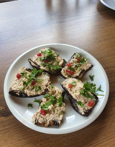Plate of traditional appetizers with herbs and pomegranate seeds.