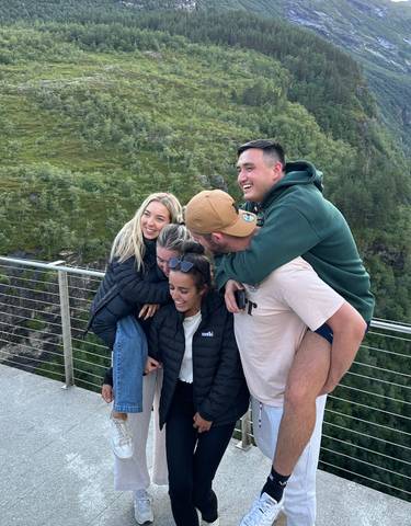 Group of friends posing joyfully in a scenic outdoor location.