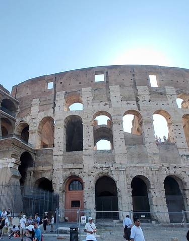 The Colosseum in Rome with tourists gathered below.
