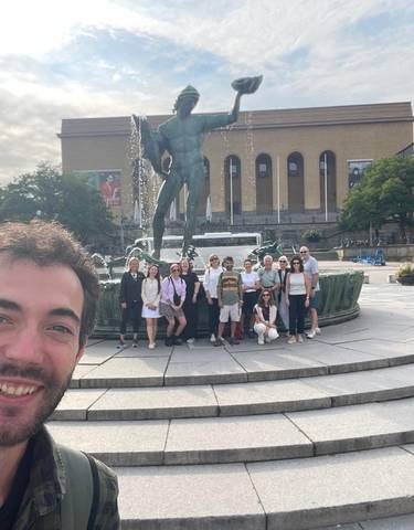 Group posing in front of a fountain with artsy backdrop.