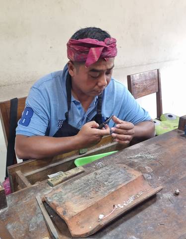 Man working on craftsmanship, concentrating on a piece in his hands.