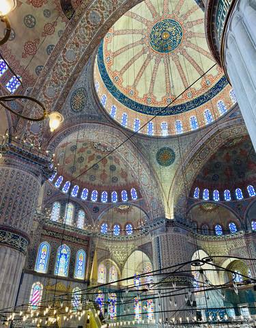 Ornately decorated interior dome with intricate designs and stained glass.