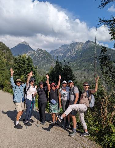 Group of hikers posing in front of a mountain landscape.