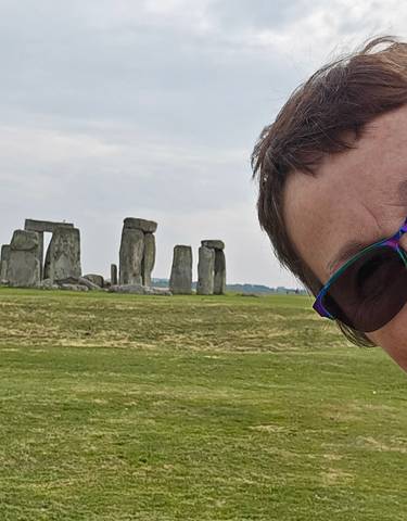 Person taking a selfie with Stonehenge in the background.