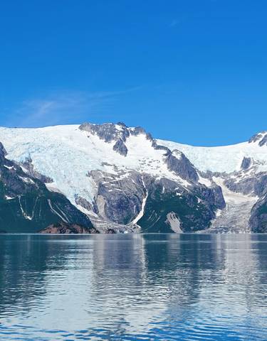 Vast glacier and mountain range with clear skies.