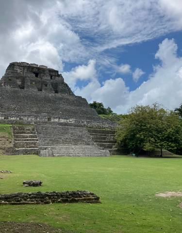 An ancient stone pyramid under a blue sky.