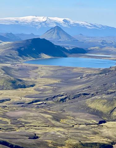 Vast aerial view of mountains and a lake in a serene landscape.