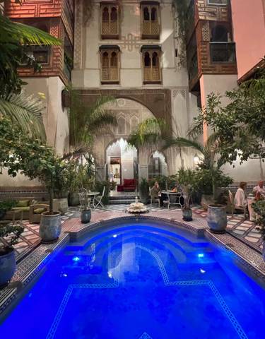 A luxurious indoor pool area with ornate decor and greenery.
