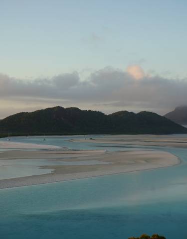 Idyllic landscape of islands with clear water and boats.