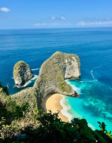 Dramatic coastal cliffs with lush greenery and blue waters.