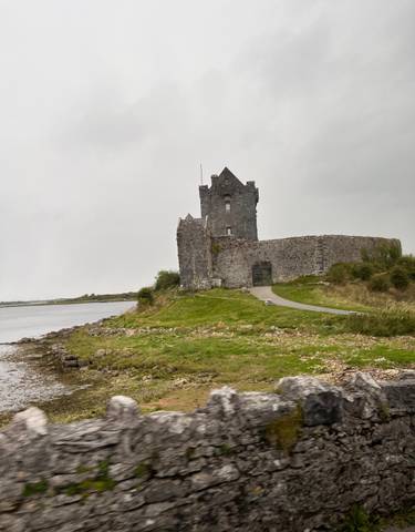 Medieval stone castle by a river.
