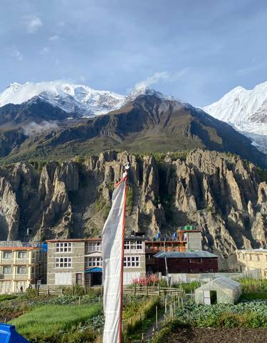 Village with colorful buildings against snow-capped mountains.