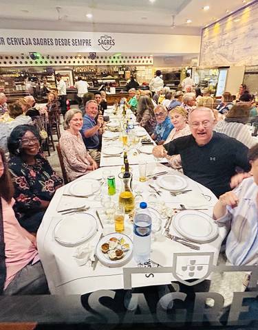Group of diners at a large table in a busy restaurant.