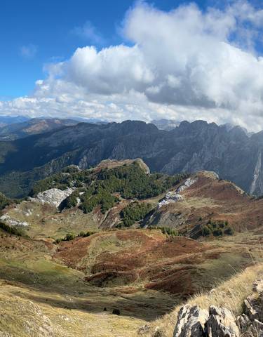Scenic mountain range with clouds casting shadows.